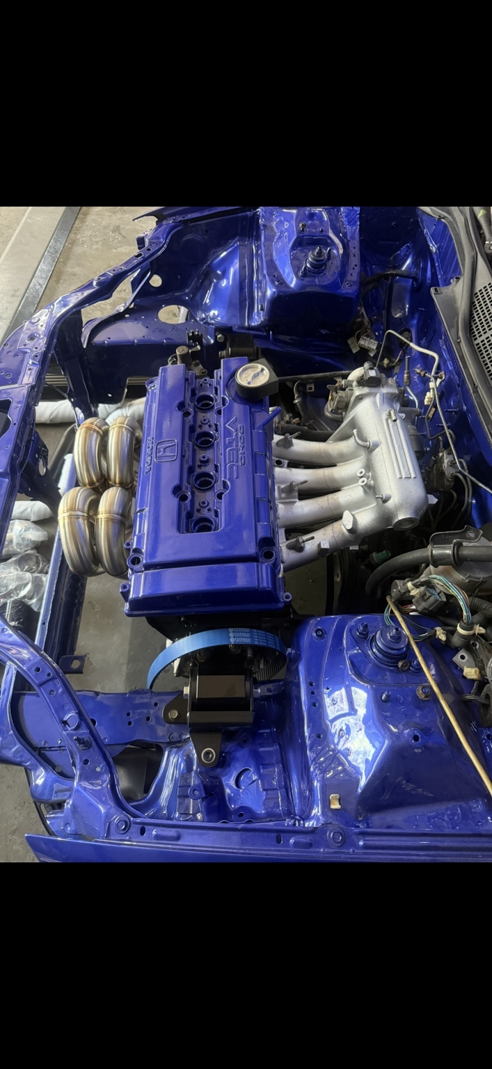 Installed Honda engine with intake manifold and blue valve cover