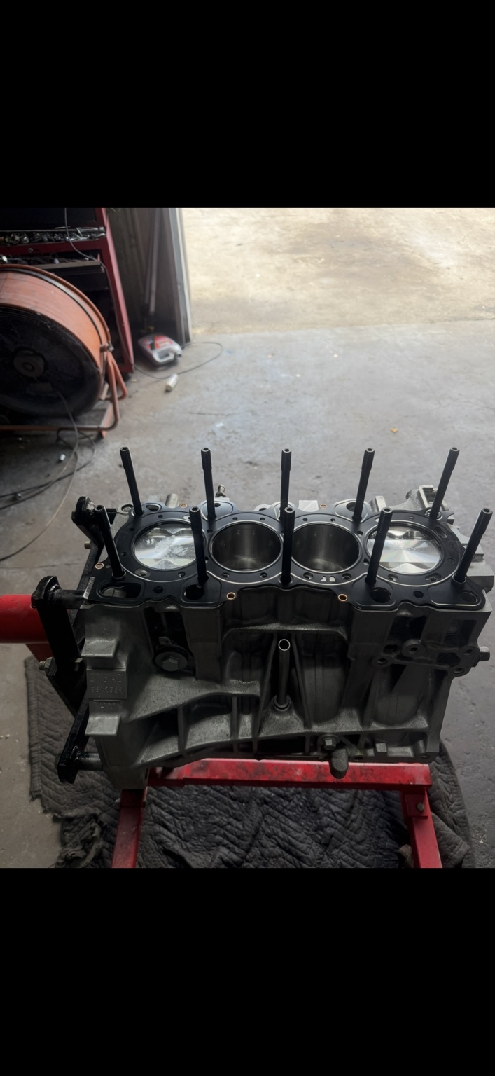 Engine block with pistons, head gasket and studs